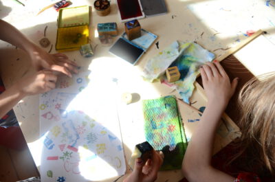 Das Bild zeigt Kinder über Stempel und Bilder geneigt